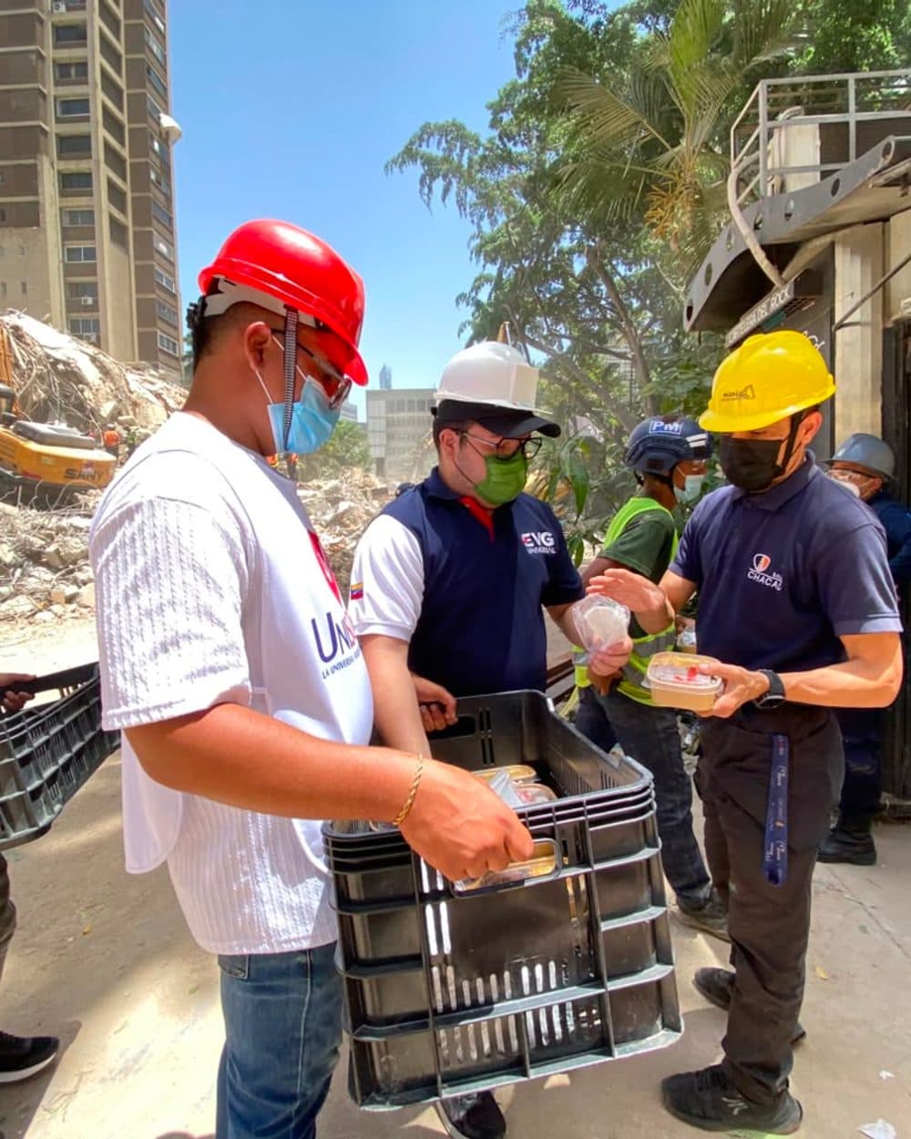 Voluntarios distribuyendo comida entre los escombros