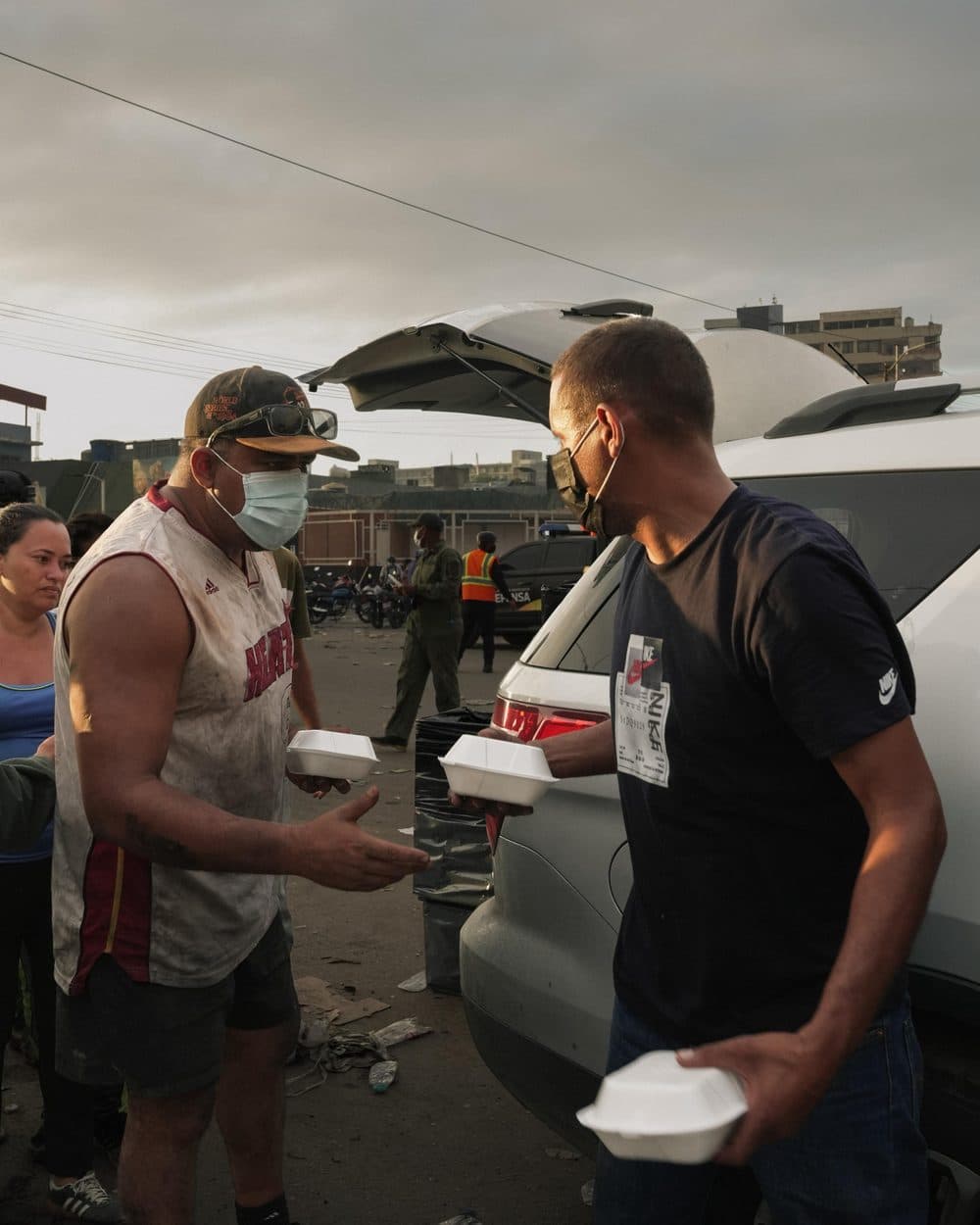 Entrega de comida junto a un vehículo de rescate